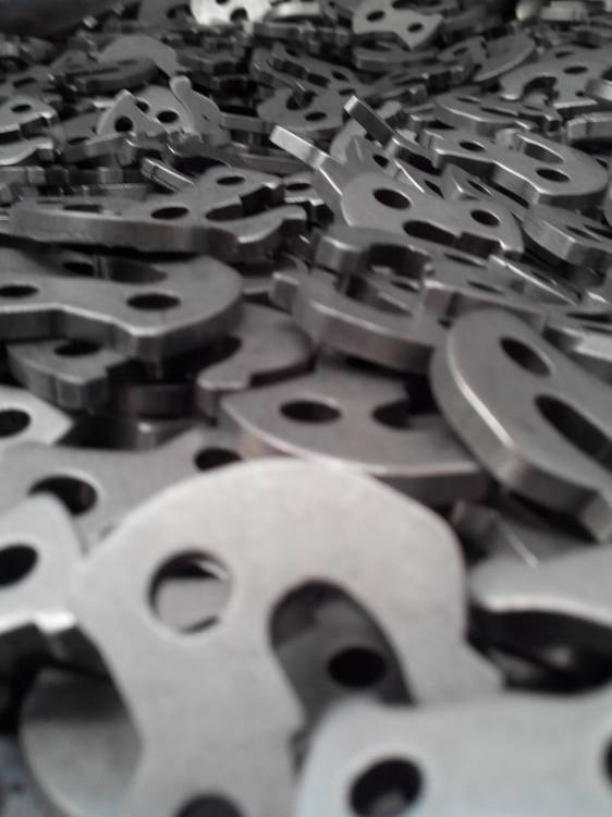 Pezzi di acciaio lavorati con la tecnica della burattatura.